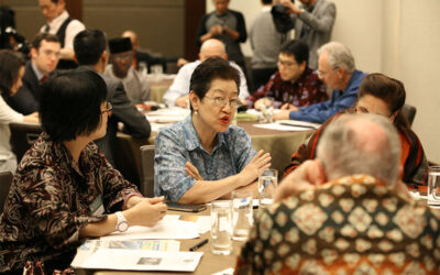 Group of professionals engaged in a roundtable discussion at a conference.