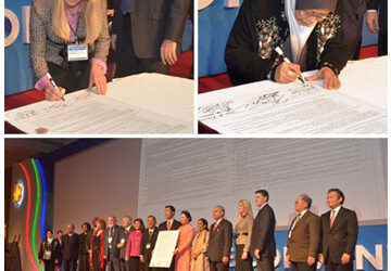 A group of people signing a document at a convention.