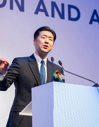 At the Global Peace Convention, a distinguished man in a suit captivates the audience with his powerful speech.