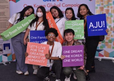 Youth at the Global Peace Youth Festival posing for a photo with signs.