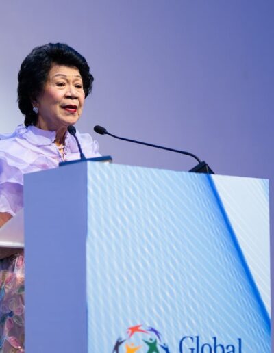 A woman delivering a powerful speech at a podium during the Global Peace Convention.