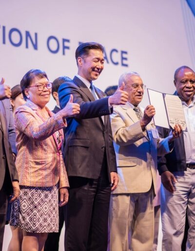 A group of people standing next to each other at the Global Peace Convention event.