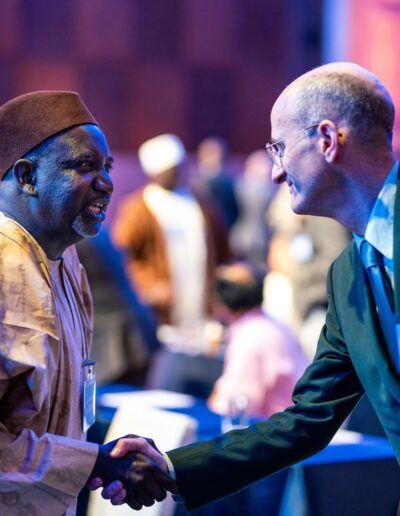 Two men shaking hands at the Global Peace Convention event.