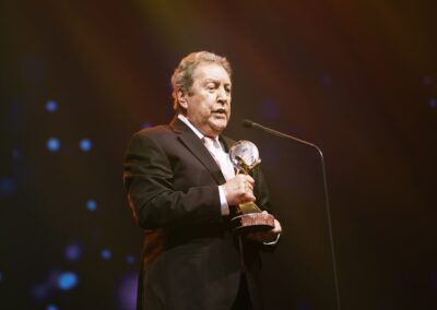 A man in a suit holding an award at the Awards Gala for Global Peace Convention 2023.